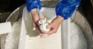 Mani di un casaro che lavora la Burrata di Andria IGP secondo la, tradizione artigianale pugliese