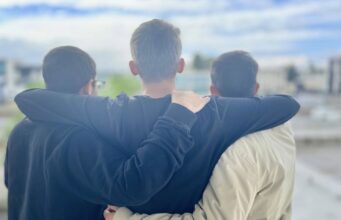 Giovani abbracciati, simbolo di unione e comunità – progetto DesTEENazione